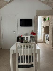 a white table and chairs in a white kitchen at Forno Mongelli 2.0 in Putignano