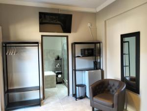 a living room with a chair and a refrigerator at Preller Accommodation in Bloemfontein