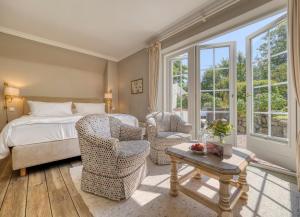 カイトゥムにあるBoutiquehotel Seiler Hof Keitumのベッドルーム1室(ベッド1台、椅子2脚、テーブル付)