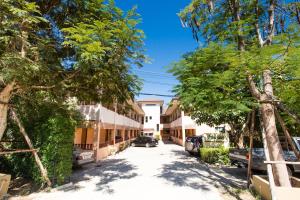 a street in front of a building with trees at Banlanna Hotel Lampang in Lampang