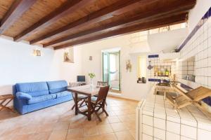 a living room with a blue couch and a table at Corricella Hammok - Gioia Apartments in Procida +20 photos
