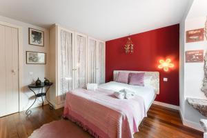 a bedroom with a bed with a red wall at GuestReady - Quintinha casas do jardim 2 in Arcos de Valdevez