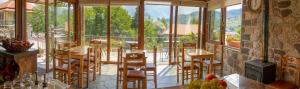 a restaurant with a balcony with tables and chairs at Liontos Rooms in Pramanta