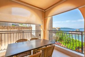 a balcony with a table and chairs and a view of the water at Apartment Moreta - Konoba More in Pržno