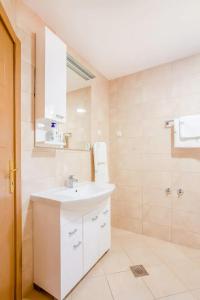 a white bathroom with a sink and a shower at Apartment Moreta - Konoba More in Pržno