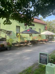 a group of tables and umbrellas in front of a building at Pension Gasthaus Schützenhaus in Waldenburg