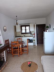 Una sala de estar con una mesa y una cocina. en Spanien Bungalow, en Teulada