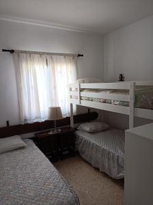 Un dormitorio con dos literas y una ventana. en Spanien Bungalow, en Teulada 11 fotos más