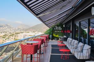 a row of red chairs and tables on a balcony at ESTIMAR Calpe Suitopia in Calpe