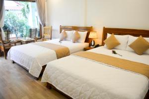 1 dormitorio con 2 camas y ventana en Ngoc Viet Bungalow, en Phu Quoc