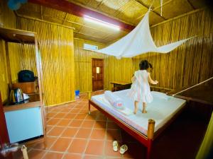 a little girl standing on a bed in a room at mekong riverside homestay in Vĩnh Long