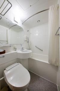 a white bathroom with a toilet and a sink at Takasaki Washington Hotel Plaza in Takasaki