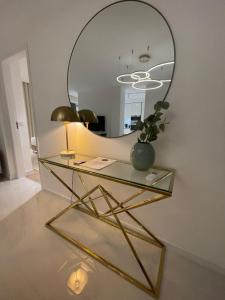 a glass table with a mirror on the wall at Suites Avenue Azores in Horta