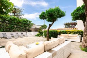 a living room with a white couch and chairs at Villa Elena by MyVillaCollection in Capri
