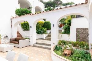 a house with a courtyard with a couch and chairs at Villa Elena by MyVillaCollection in Capri