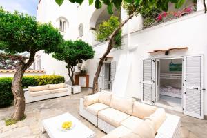 a patio with couches and a table and trees at Villa Elena by MyVillaCollection in Capri