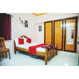 a bedroom with a bed with a red blanket on it at Garuda Grand in Tirupati +9 photos