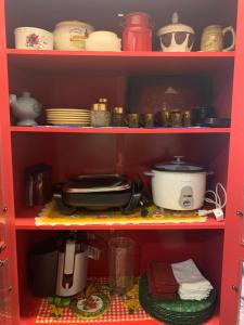 a red shelf with dishes and pots and pans at Chácara Primavera in Capão Bonito +11 photos