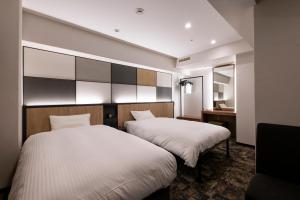 a hotel room with two beds and a mirror at Takasaki Washington Hotel Plaza in Takasaki