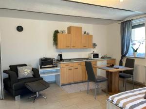 a living room with a kitchen and a table and chairs at CSA- Ferienwohnung in Mogersdorf