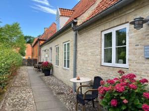 a brick building with a table and chairs and flowers at Brodremenighedens Hotel, BW Signature Collection in Christiansfeld