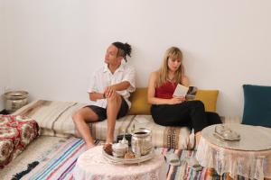 a man and a woman sitting on a couch at Hostel le Rhumel in Constantine