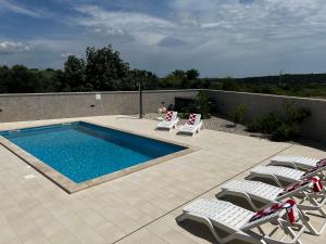 a swimming pool with lounge chairs and a swimming pool at Villa Mare - Modern villa with swimming pool and jacuzzi in Pula +18 photos