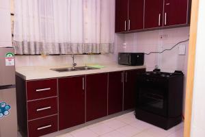 una cocina con fregadero y microondas en RM Luxury Homes, en Nairobi 14 fotos más