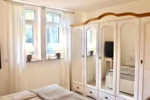 a bedroom with a large white cabinet and windows at Ferienwohnung Pipergast mit Terrasse in Oerlinghausen