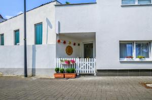 科隆Stylisch und Schick, neue Wohnung, U-Bahn 2 Minuten的一座有盆栽和白色篱笆的白色房子