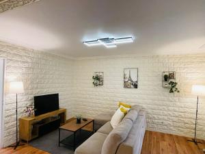 a living room with a couch and a tv at Maison Familiale avec Jardin in Ozoir-la-Ferrière