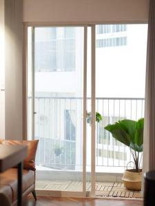 una sala de estar con una gran ventana con una planta en Daisy Home Luxury, en Ấp Mỹ Hòa
