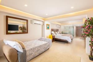 a hotel room with two beds and a tv at Serene Beachfront Escape Includes Delicious Breakfast in Puerto Vallarta +12 photos