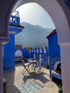 eine Terrasse mit Stühlen und einem Tisch in einem blauen Gebäude in der Unterkunft Dar Aldea in Chefchaouen