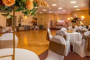 a banquet hall with white tables and chairs and flowers at Royal Clifton Hotel in Southport