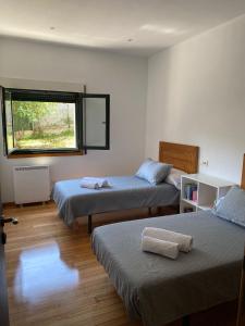 a room with two beds and a window at Carballeira in Moraña
