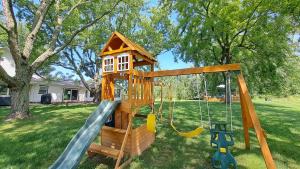 a wooden playground with a slide and a play house at Meadow Sunrise in Bridgman