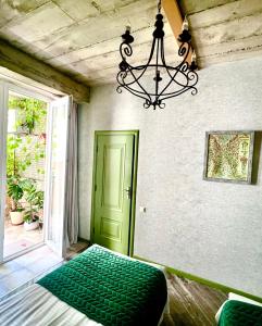 Habitación con puerta verde y lámpara de araña. en T2&T3 Apartments LEVANTO, en Tiflis