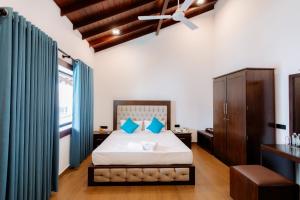 una camera da letto con un grande letto con tende blu di KADUPUL By Serenity a Negombo