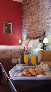 ein Tablett mit Brot und zwei Gläsern Orangensaft in der Unterkunft Hotel La Era de Aracena - Adults Only in Aracena