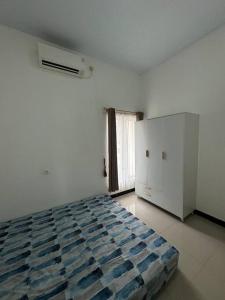 a white room with a bed and a window at Sapphire Town House Purbalingga in Purbolinggo