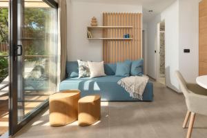 a living room with a blue couch and a table at Pine Beach Mobile homes all inclusive in Pakoštane