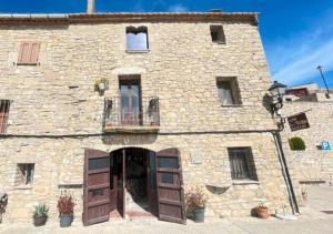 a large stone building with a door and a balcony at Lo Mirador De Forès in Tarragona