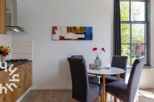 a dining room with a table and chairs at OV593 - 4P apartment in the heart of Giethoorn on the village canal in Giethoorn