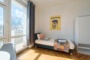 a small bedroom with a bed and a large window at Urbannestgroup - City view N8 in Warsaw