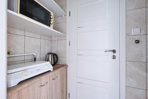 a small kitchen with a sink and a microwave at Urbannestgroup - City view N8 in Warsaw