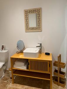 La salle de bains est pourvue d'un lavabo et d'un miroir sur une table. dans l'établissement Villa Hawwah, à Sète 37 autres photos