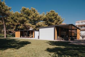 een huis met een grote witte garage in een tuin bij Mobile House Pirovac Kamp Kerido in Pirovac