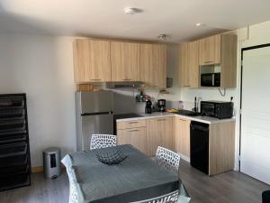a kitchen with wooden cabinets and a table and a table and chairs at Appartement agréable à deux pas du plan d'eau in Embrun