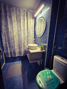 Un baño azul con lavabo e inodoro. en Mony Apartaments, en Roman